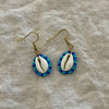 Beaded cowrie shell earrings in ocean blue and teal seed beads on gold hooks
