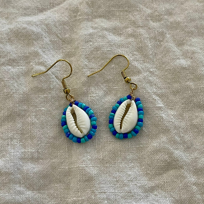 Beaded cowrie shell earrings in ocean blue and teal seed beads on gold hooks
