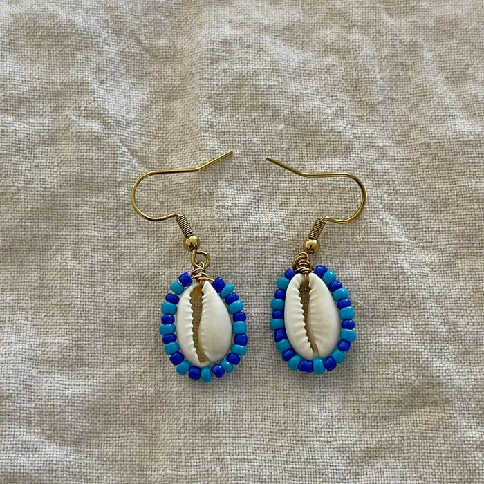 Handcrafted cowrie earrings with cobalt blue and aqua seed beads, gold hook fastening
