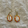 Beaded cowrie shell earrings with orange seed beads on gold hooks
