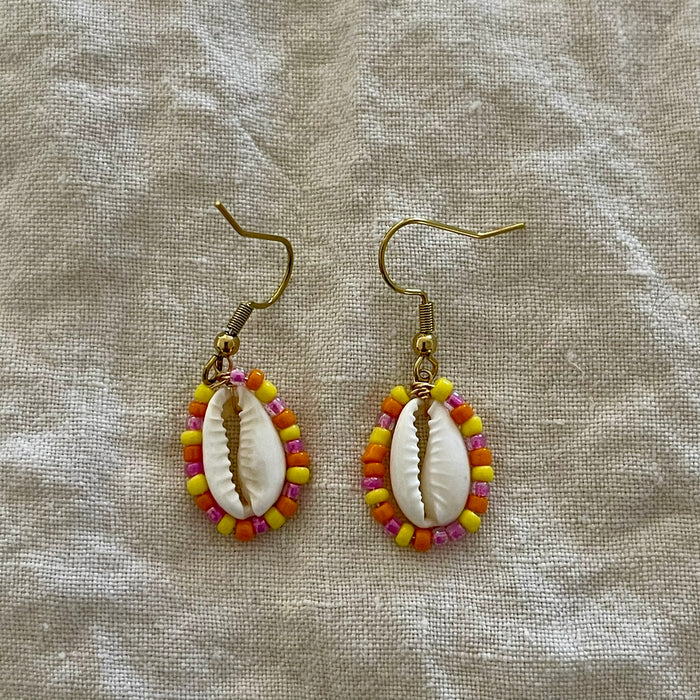 Beaded cowrie shell earrings with orange seed beads on gold hooks
