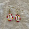 Beaded cowrie shell earrings with red and pink seed beads on gold hooks
