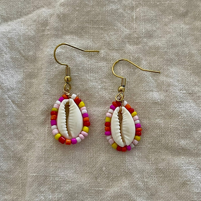 Beaded cowrie shell earrings with red and pink seed beads on gold hooks
