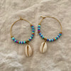 Blue and purple polymer clay bead hoop earrings with natural cowrie shell drop and gold-tone accents

