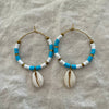 Sky blue polymer clay bead hoop earrings with natural cowrie shell drop and gold-tone accents
