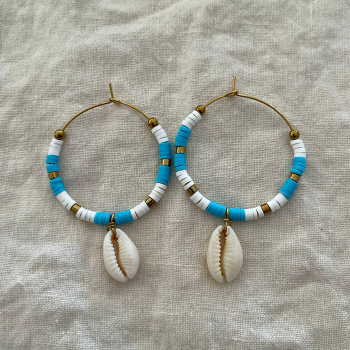 Sky blue polymer clay bead hoop earrings with natural cowrie shell drop and gold-tone accents
