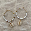 White polymer clay bead hoop earrings with gold-tone accents and natural cowrie shell drop
