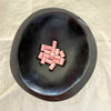 Blush pink ceramic barrel beads in a dark bowl - Travel and Tide Coastal Notions.
