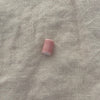 Blush pink ceramic barrel bead on white linen - Travel and Tide Coastal Notions
