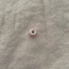 Blush pink ceramic barrel bead showing wide stringing hole - Travel and Tide Coastal Notions

