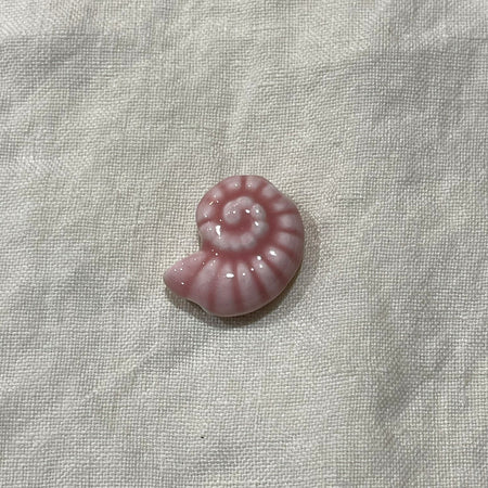 Blush pink ceramic nautilus shell bead on white linen - Travel and Tide Coastal Notions
