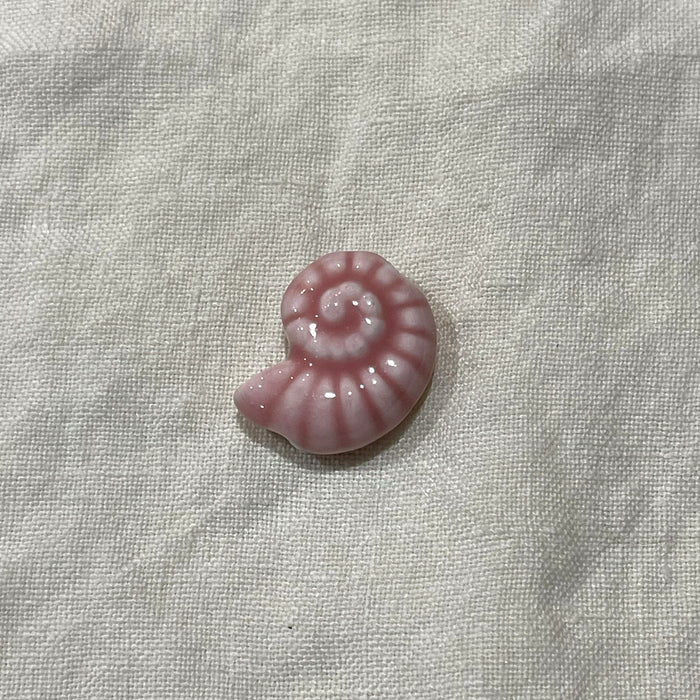 Blush pink ceramic nautilus shell bead on white linen - Travel and Tide Coastal Notions
