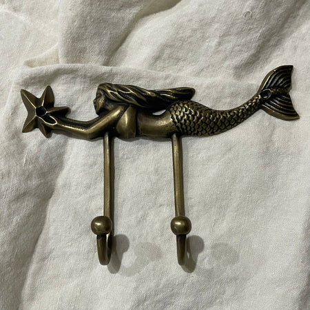 Antique brass mermaid double wall hook with starfish detail, full product view on white linen background
