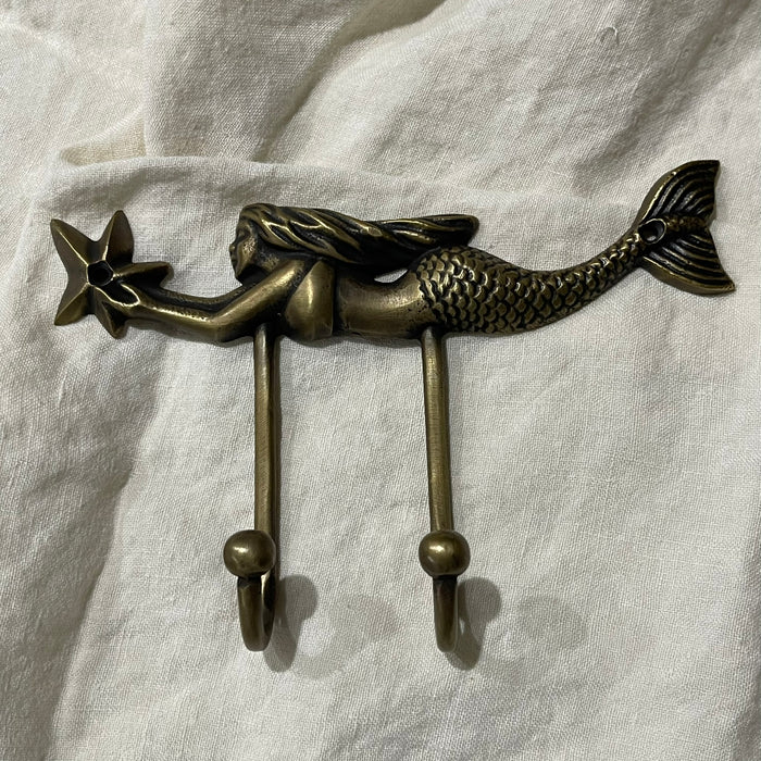 Antique brass mermaid double wall hook with starfish detail, full product view on white linen background
