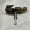 Rear view of brass mermaid drawer knob showing screw bolt and mermaid tail on white linen
