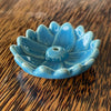 Blue glazed ceramic lotus flower incense holder, angled view showing smooth rounded petals and central incense hole

