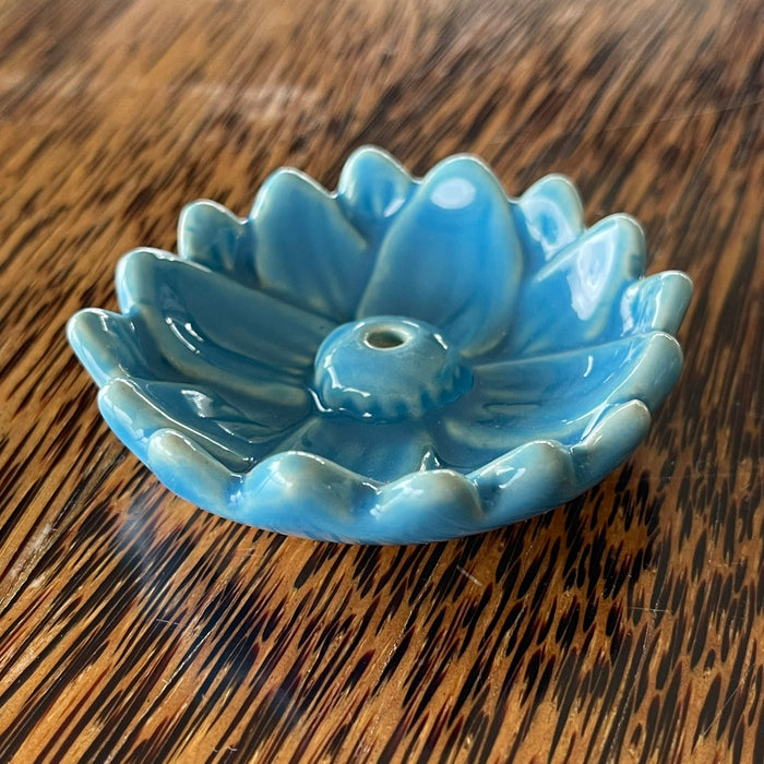 Blue glazed ceramic lotus flower incense holder, angled view showing smooth rounded petals and central incense hole
