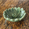 Green glazed ceramic lotus flower incense holder, angled view showing deep sage green glaze and layered petal detail
