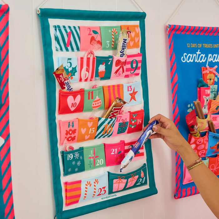 Reusable fabric Christmas Advent Calendar filled with small gifts and treats in a festive styled home
