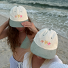 Person wearing the Flower Bloom Hat outdoors in a coastal setting
