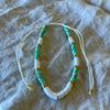 Green polymer clay bead anklet with gold-tone rings and white shell beads on adjustable white cord

