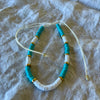 Teal polymer clay bead anklet with gold-tone rings and white shell beads on adjustable white cord
