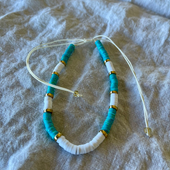 Teal polymer clay bead anklet with gold-tone rings and white shell beads on adjustable white cord
