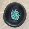 Light teal ceramic barrel beads in a dark bowl - Travel and Tide Coastal Notions
