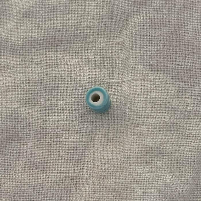 Light teal ceramic barrel bead showing wide stringing hole - Travel and Tide Coastal Notions
