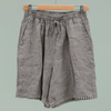 100% linen Bermuda shorts in taupe with pom-pom trim hem and elasticated drawstring waist on hanger
