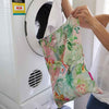 Linen Tiki laundry bag styled in bedroom - reusable linen cotton laundry storage
