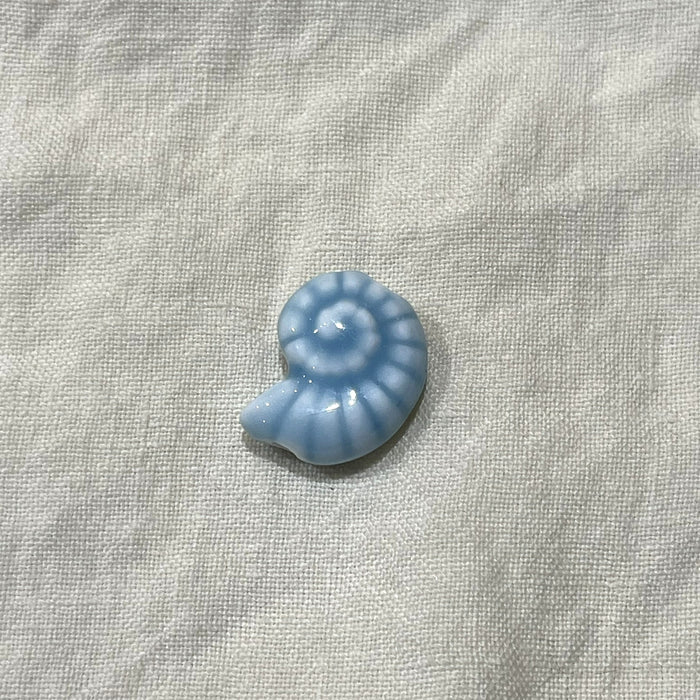 Ocean blue ceramic nautilus spiral bead on white linen - Travel and Tide Coastal Notions
