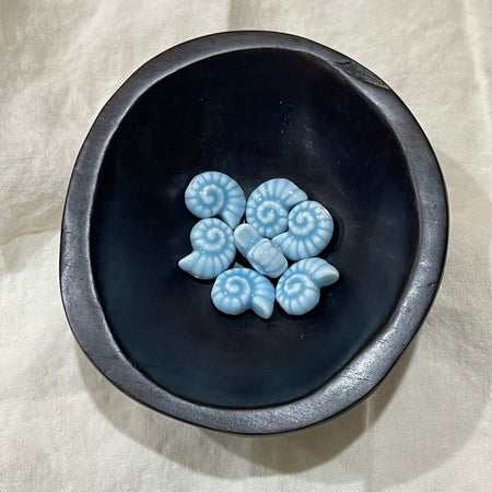 Ocean blue ceramic nautilus spiral beads in a dark bowl - Travel and Tide Coastal Notions
