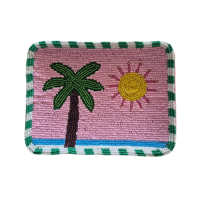 Pink beaded trinket tray with a green palm tree, yellow sun, blue stripe and green and white striped border