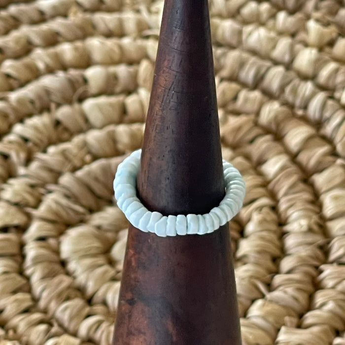 Pale blue shell disc stretch ring on wooden cone display, soft powder blue shell beads on elastic band
