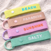 SALTY keyring clipped to a beach bag — embroidered coastal keychain by Daydream Prints
