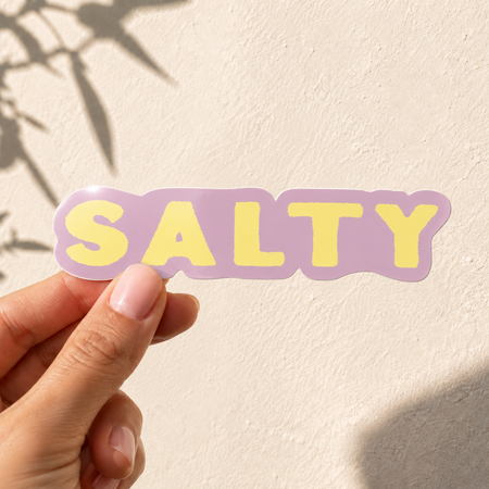 Glossy vinyl sticker with bold retro 'Salty' typography in warm coastal tones