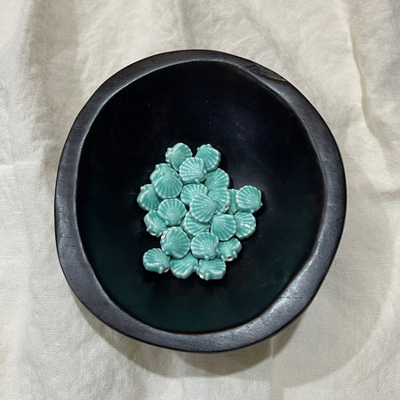 Seafoam aqua ceramic scallop shell beads in a dark bowl - Travel and Tide Coastal Notions
