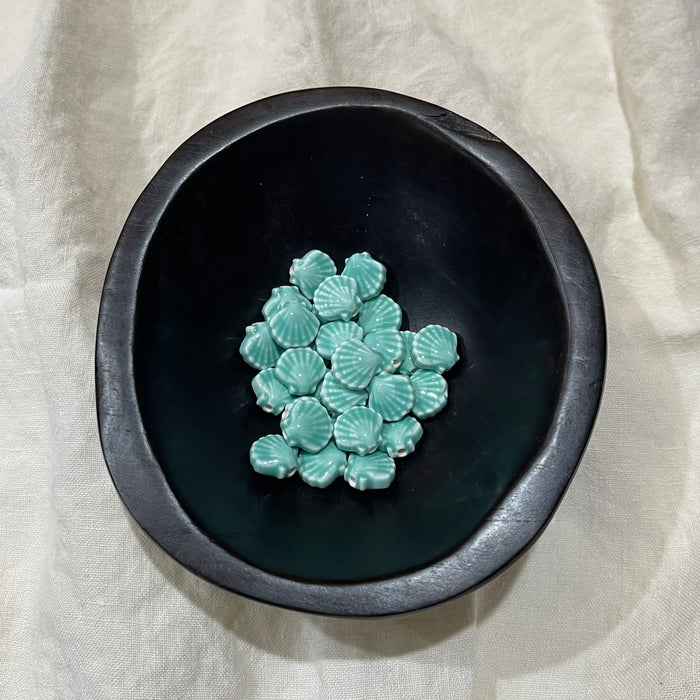 Seafoam aqua ceramic scallop shell beads in a dark bowl - Travel and Tide Coastal Notions
