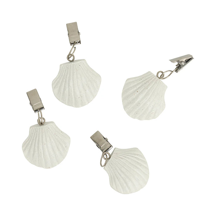 Close-up detail of shell design tablecloth weight clip attached to a white tablecloth
