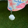 Shell tablecloth weight clips attached to the edge of a tablecloth on an outdoor dining table
